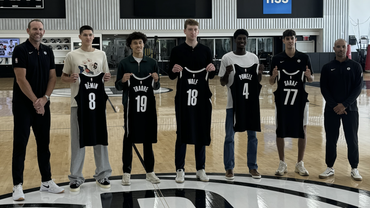 Brooklyn Nets General Manager Sean Marks (left) and head coach Jordi Fernandez (right) pose with the team's rookie class at HSS Training Center.